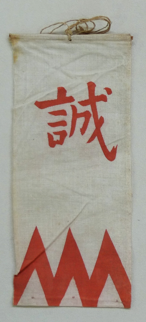 Shinsengumi sleeve badge bearing the red character makoto (“sincerity”) above a stylized mountain-like pattern. According to the Ryozen Museum of History, the badge was worn on the sleeve by Shinsengumi corpsmen for identification and to prevent accidental clashes between members. Formerly owned by Shimada Kai. Courtesy of the Ryozen Museum of History.
